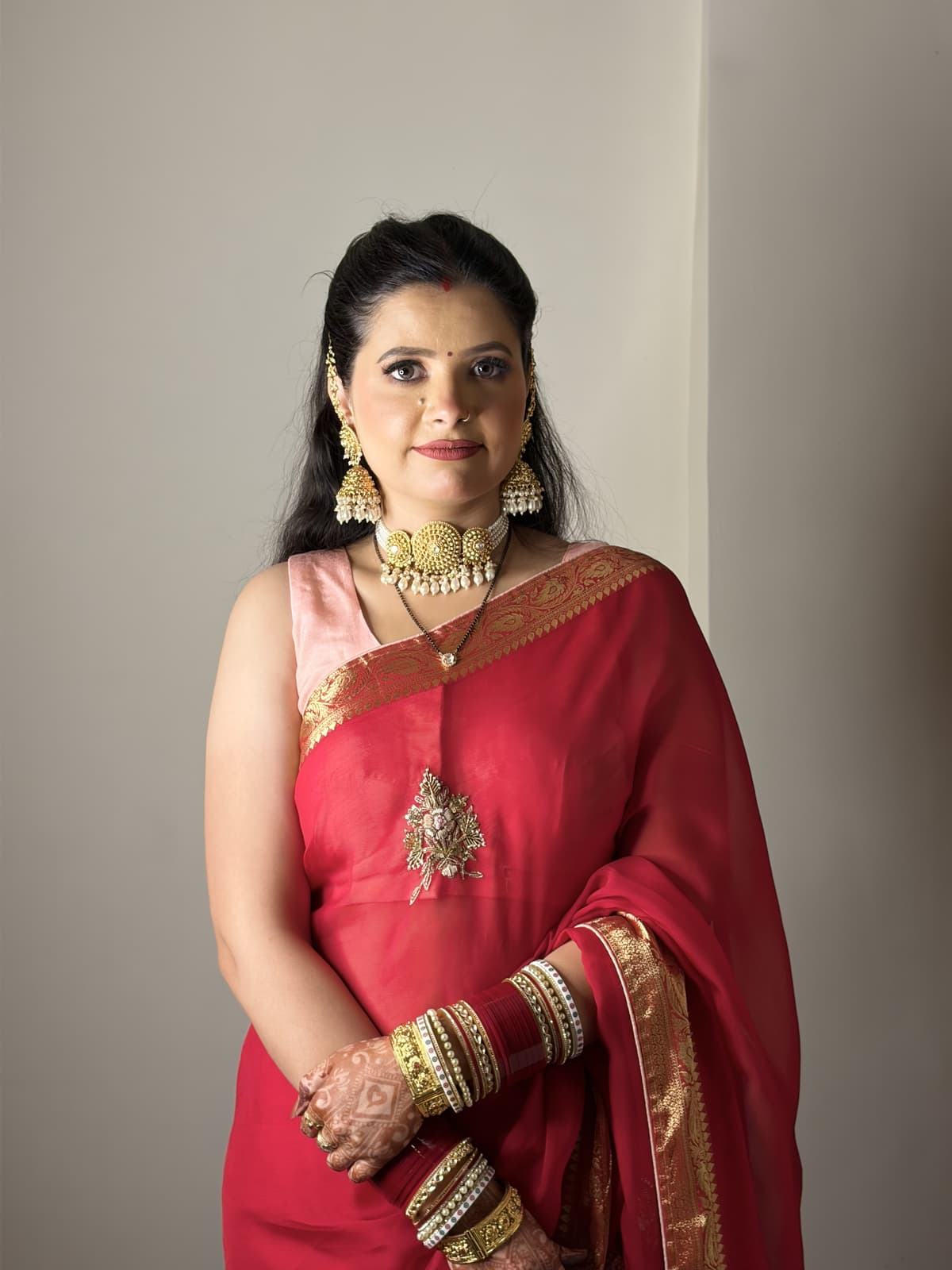 Rimple Uppal in her red saree with polished reception makeup, softly defined eyes and muted rose lips