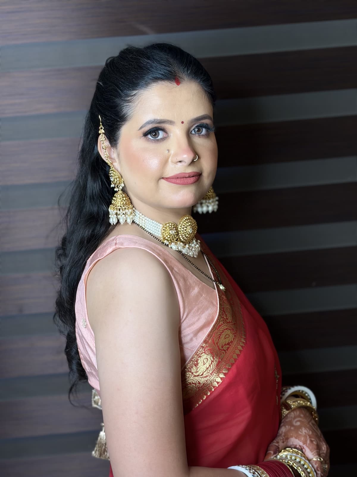 Close reception portrait of Rimple Uppal with luminous skin, defined eyeliner and muted rose lips