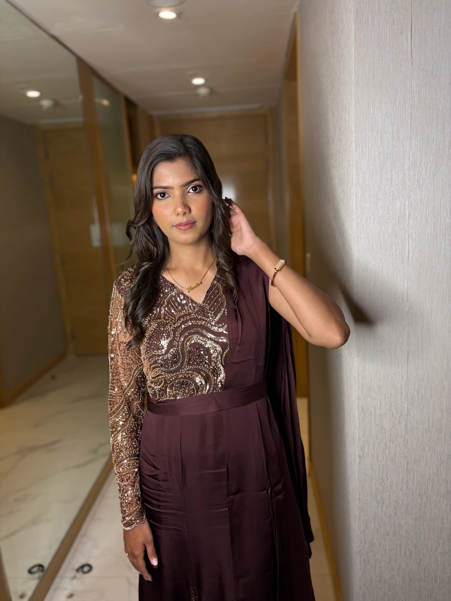 Full-length party look with natural glowing makeup and a plum embroidered outfit