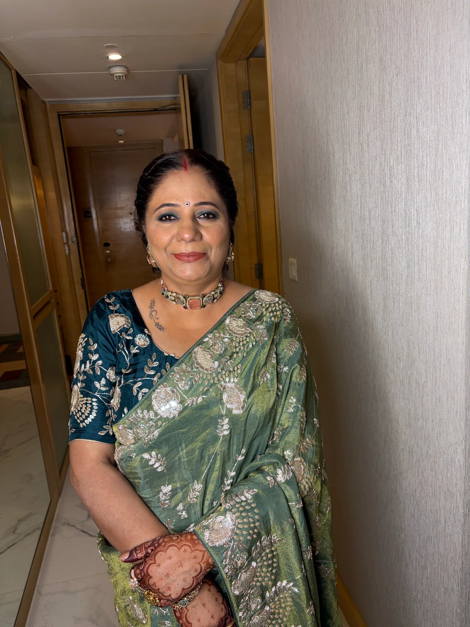 Celebration makeup with defined eyes and rose lips, paired with a green floral saree and gold jewellery