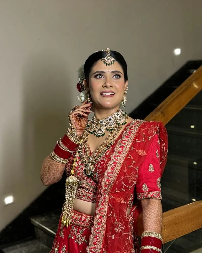 Shilpa in her red bridal lehenga with makeup and hairstyling by Shivani