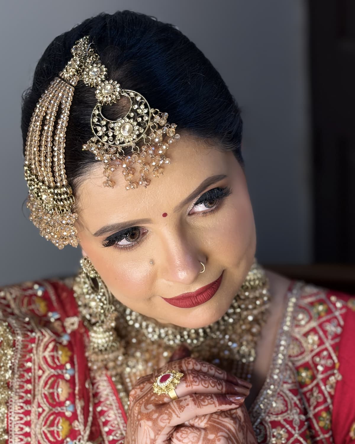 Close portrait of Rimple Uppal showing her finished bridal makeup and jewellery
